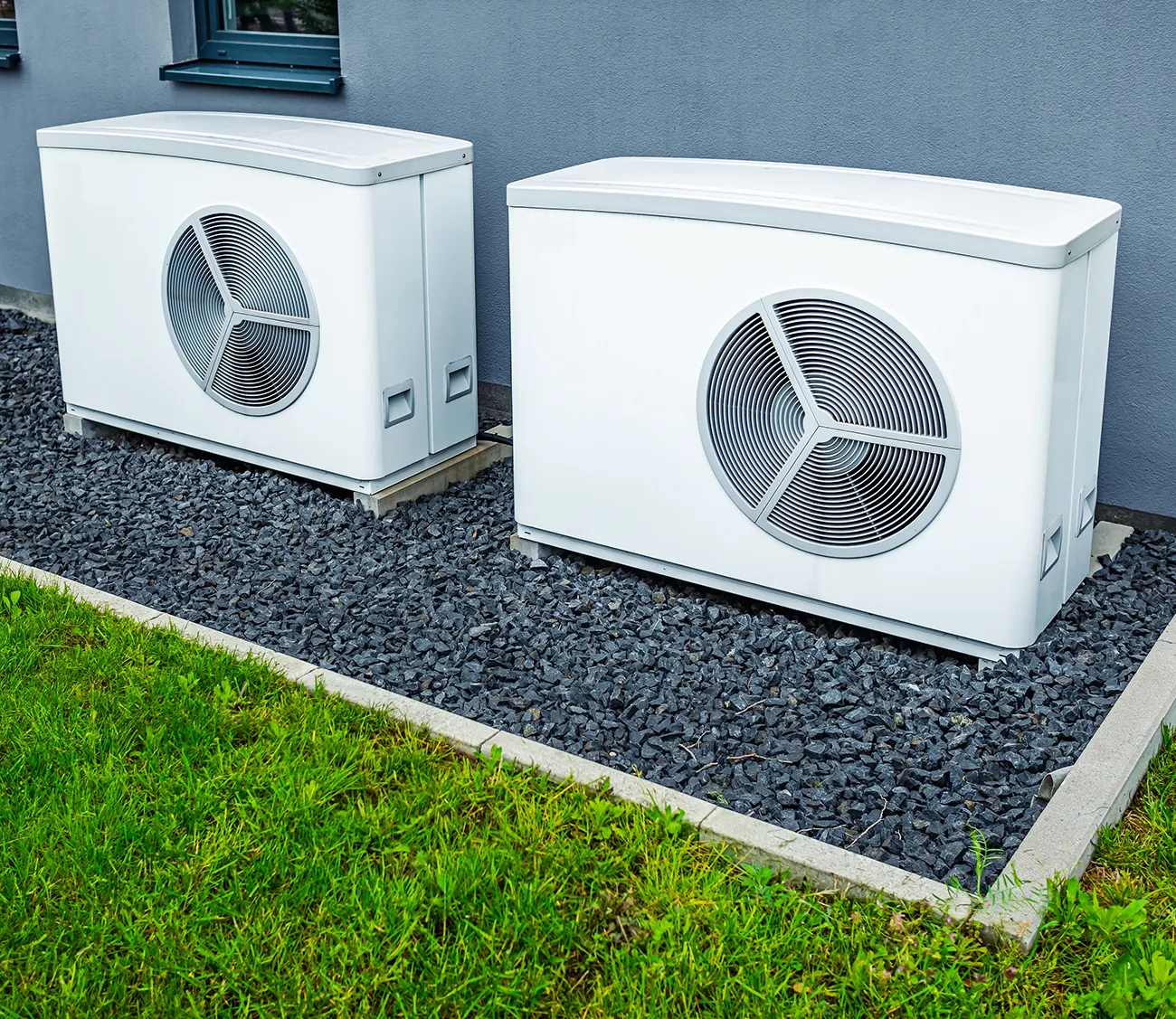 Two air source heat pumps installed outside of new and modern city house